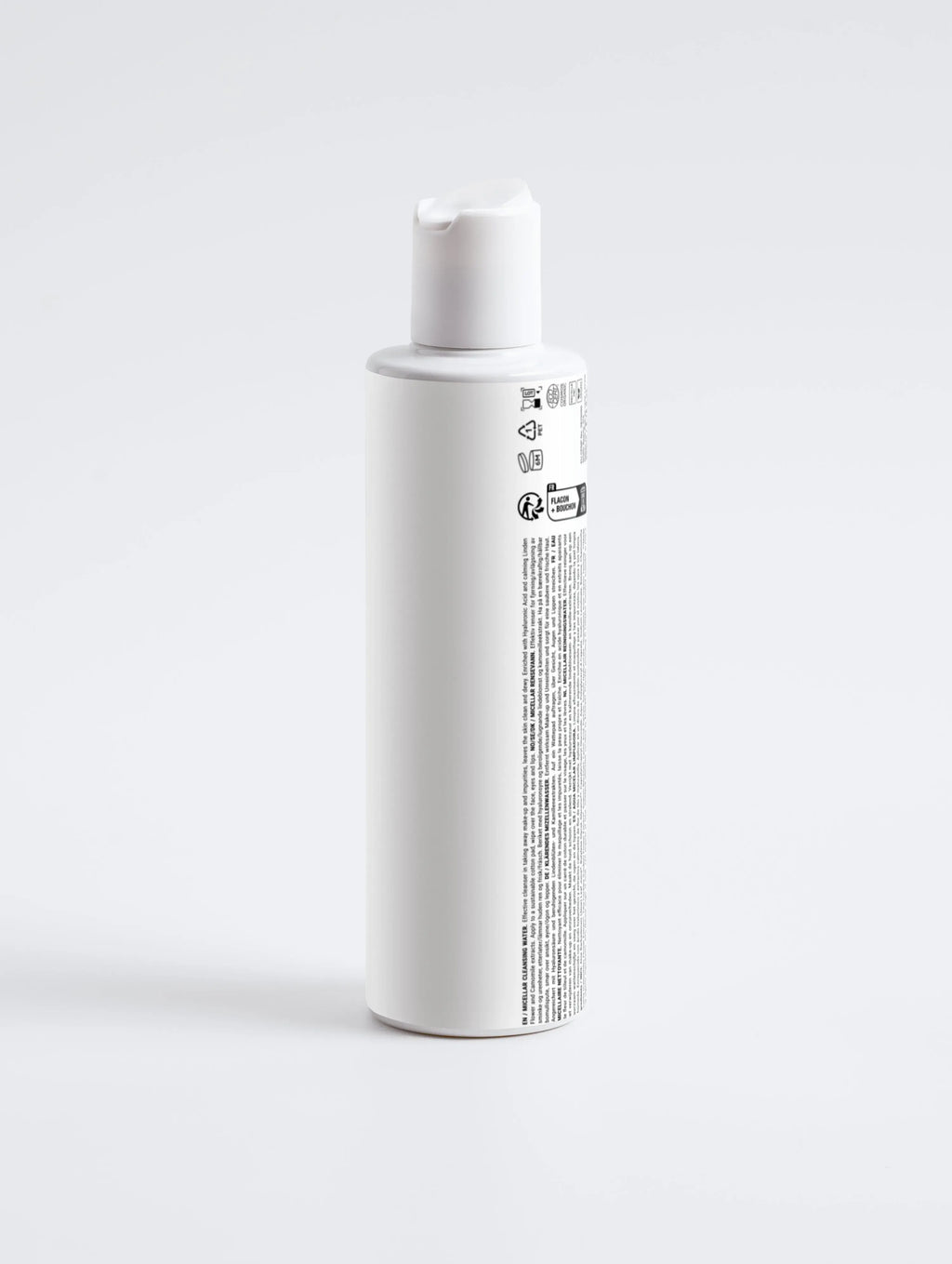 Witte skincare fles met klikdop en productinformatie, minimalistisch design, op witte achtergrond.