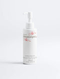 Gezicht cleanser voor onzuivere huid in witte pompflacon met roze bloemen, minimalistisch design.